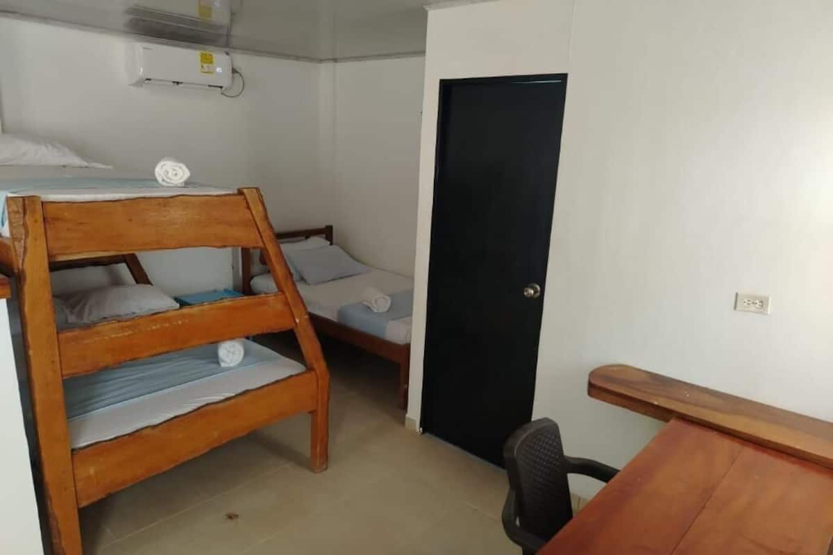 Una habitación con dos literas, un escritorio y una silla.