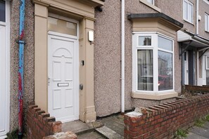 Traditional home with a classic front door, bay window, and stucco exterior.