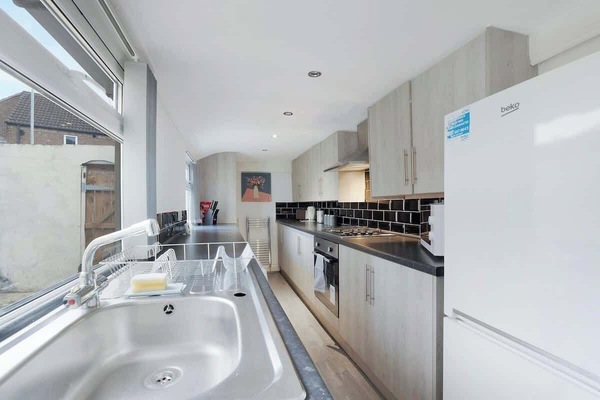 Kitchen equipped with all essentials, including a microwave, oven, toaster, kettle, fridge and full cookware set.