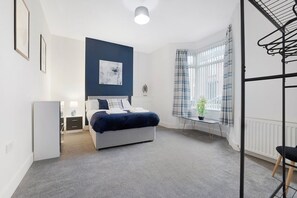 Relax in a serene bedroom with a comfortable bed, bedside table, and potted plant.