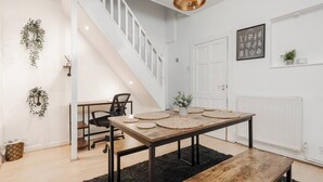 A modern interior with a wooden dining table, black metal legs, and a black rug. - LFC Stay | 1 Min to Stadium | W/M | Pet Friendly (Anfield)