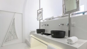 A modern bathroom with two black sinks, a large mirror, and a towel rack.