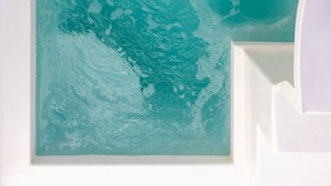 A large, rectangular, teal-colored artwork on a white wall. - Santorini Sun Villa Two in Oia | Private Hot Tub (Oia)