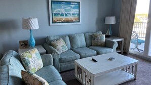 A living room with a sofa, coffee table, lamps, and a framed picture on the wall. - Ease, Comfort and Tranquility at Lake Town Wharf Resort, Panama City Beach, FL (Panama City Beach)
