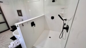 A modern bathroom with a shower, toilet, and sink. - Cora's Suite at the Flyin H Ranch (Tyler)