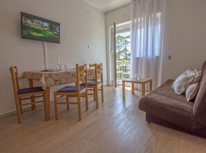 Enjoy meals in the dining area with a flat-screen TV above and access to a balcony.