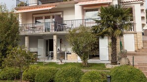 A multi-story residential building with balconies, outdoor seating, and a well-maintained garden. - Beachfront Crikvenica Apartments with Sea View - Standard Studio Apartment with Sea View (Crikvenica)