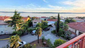 Un quartier résidentiel avec des maisons, une route et une étendue d’eau en arrière-plan.