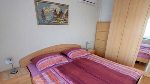 Une chambre à coucher avec un lit, des tables de chevet, une commode et un tableau au mur.
