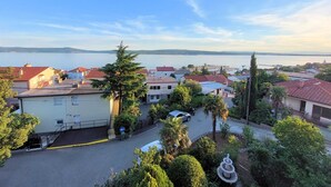 A residential area with houses, a road, and a body of water in the background.