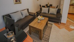 Una sala de estar moderna con un sofá, una mesa de centro y un ordenador portátil sobre una mesa.