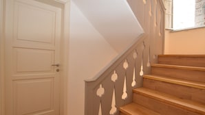 Una scala con gradini in legno e una porta bianca in cima.