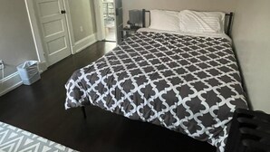 A bedroom with a bed, a nightstand, and a trash bin. - Homestay In Fields Corner Area Boston (Boston)