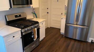 Una cocina con un refrigerador de acero inoxidable, un microondas y una estufa.