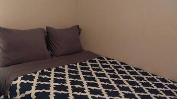 Un letto con una coperta fantasia e due cuscini.