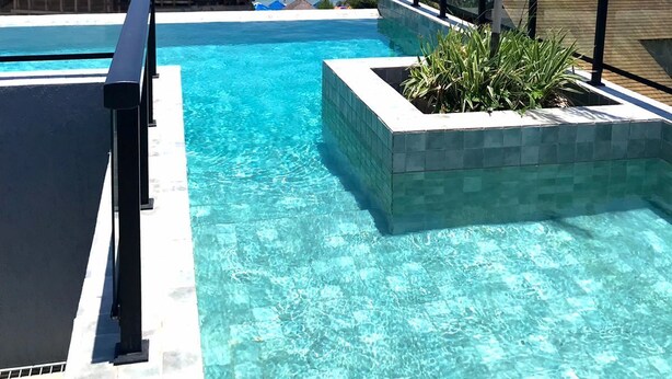 A clear blue pool with a view of the ocean and palm trees. - Apartamento Porto de Galinhas, Centro, Vista Mar, Ipojuca (Maracaipe Ipojuca)