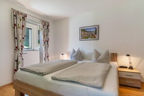A neatly made bed with a headboard, a bedside table with a lamp, and a framed picture on the wall. - Holiday Apartment "3" with Mountain View, 3 Shared Terraces & Wi-Fi (Oppenau)
