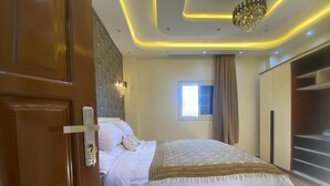 Un dormitorio moderno con una cama grande, un armario y una ventana con cortinas.