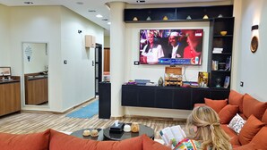 Una sala de estar con televisor, sofá y una mesita de centro.
