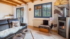 Ein gemütliches Wohnzimmer mit Kamin, Ledersofa und Glastisch.