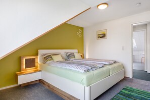 Une chambre à coucher avec un lit, une table de chevet et un cadre photo.