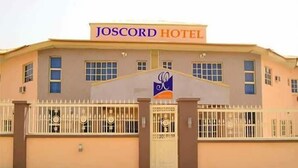 A hotel named JOSCORD HOTEL with a gated entrance and a logo on the facade. - Joscord Hotel  (Asokoro)