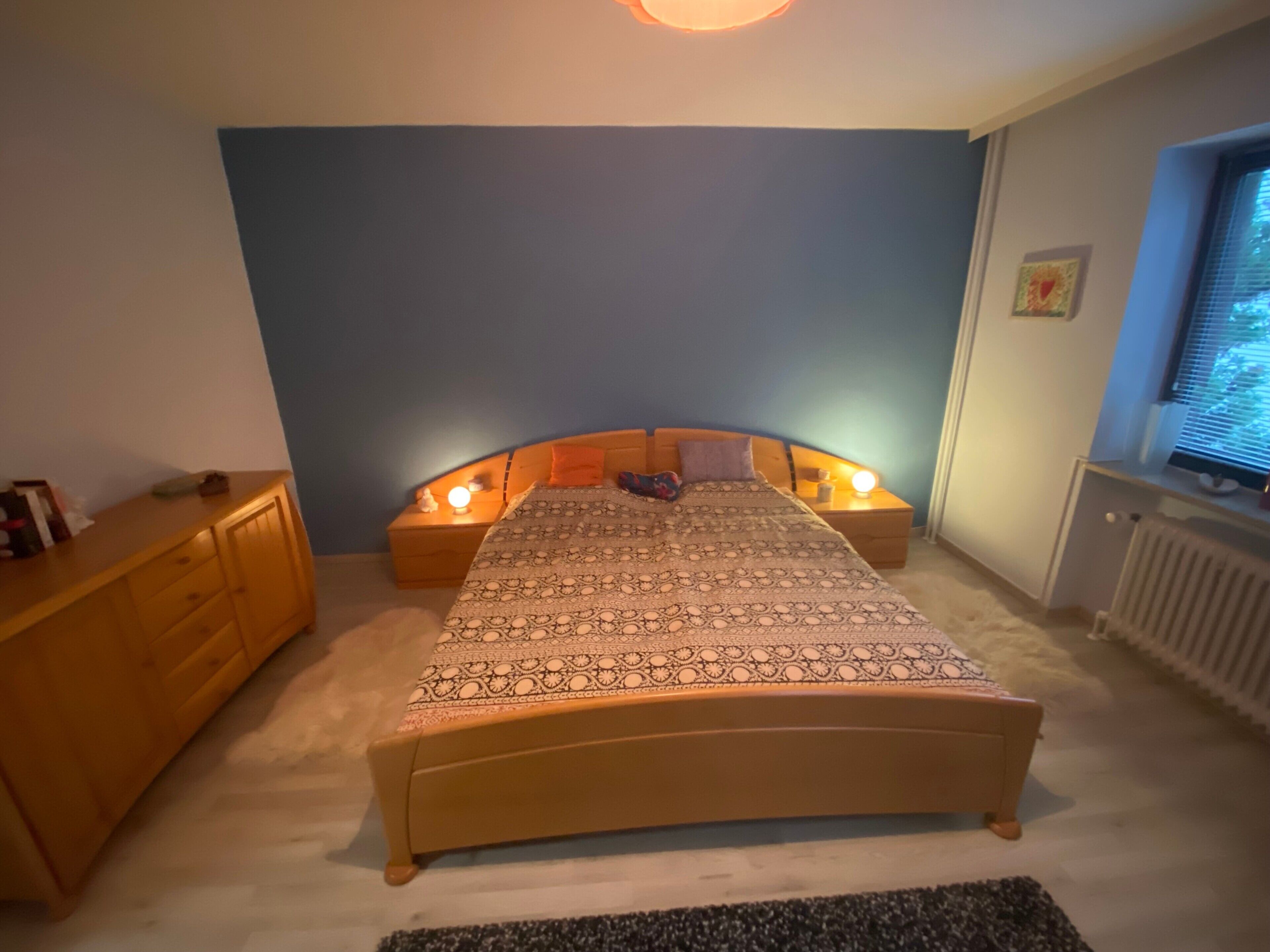 Una camera da letto con un letto, comodini, una cassettiera e una finestra.