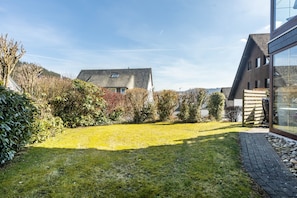 Een woonhuis met een verzorgd gazon, een modern huis met grote ramen en een verhard pad.