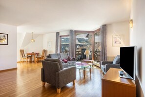 A modern living room with a sofa, armchair, glass coffee table, and a flat-screen TV. - Apartment 'Type 5' (Willingen (Upland))