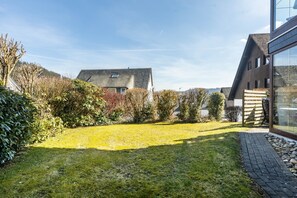 Il s’agit d’une propriété résidentielle dotée d’une pelouse bien entretenue, d’une maison moderne avec de grandes fenêtres et d’un chemin pavé.