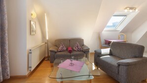 En moderne stue med et glasbord, en sofa og et spisebord med stole.