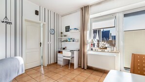 A room with a white desk, chair, and a window with a view of a cityscape. - Holiday Apartment 'Friedrichskoog Spitze' with Private Terrace and Wi-Fi (Friedrichskoog)
