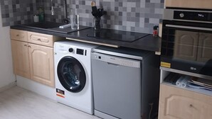 Eine moderne Küche mit Waschmaschine, Backofen und Mikrowelle.
