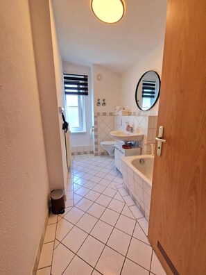 A bathroom with a toilet, sink, and bathtub. - Apartment 'Fewo Anne, Großzügige' with Private Terrace, Shared Garden and Wi-Fi (Chemnitz)