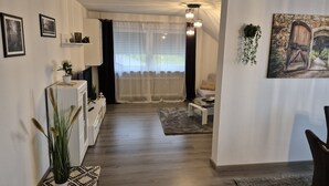 Una sala de estar moderna con chimenea, comedor y cocina.