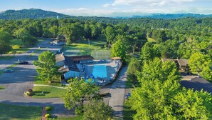 A golf course with a swimming pool, tennis courts, and a clubhouse.