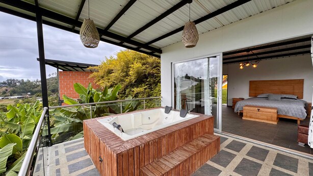 A modern outdoor bathroom with a wooden tub, a glass-enclosed shower, and a balcony with a view of the surrounding landscape. - GLAMPING WITH POOL AND JACUZZI AT GUATAPE  (Antioquia)