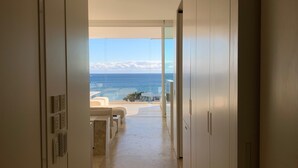 A hallway leading to a balcony with a view of the sea.