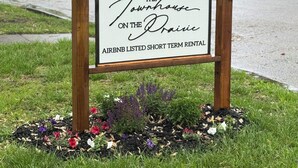 A sign for 'The Townhouse on the Drains' Airbnb, indicating it is a short-term rental. - Nicely Located 2-bedroom duplex apartment newly updated in Herington. (Herington)