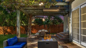 A patio with a fire pit, outdoor furniture, and a covered seating area.
