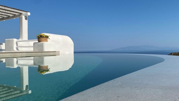 A infinity pool with a clear blue sea view, white architectural elements, and a potted plant. - Villa Camelia 2 - 2BR  - Private Pool & Jacuzzi - Sea View - Psarou (Nammos) (Mikonos)