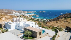 A coastal village with white buildings, a stone structure, and a view of the sea with boats. - Villa Camelia 2 - 2BR  - Private Pool & Jacuzzi - Sea View - Psarou (Nammos) (Mikonos)