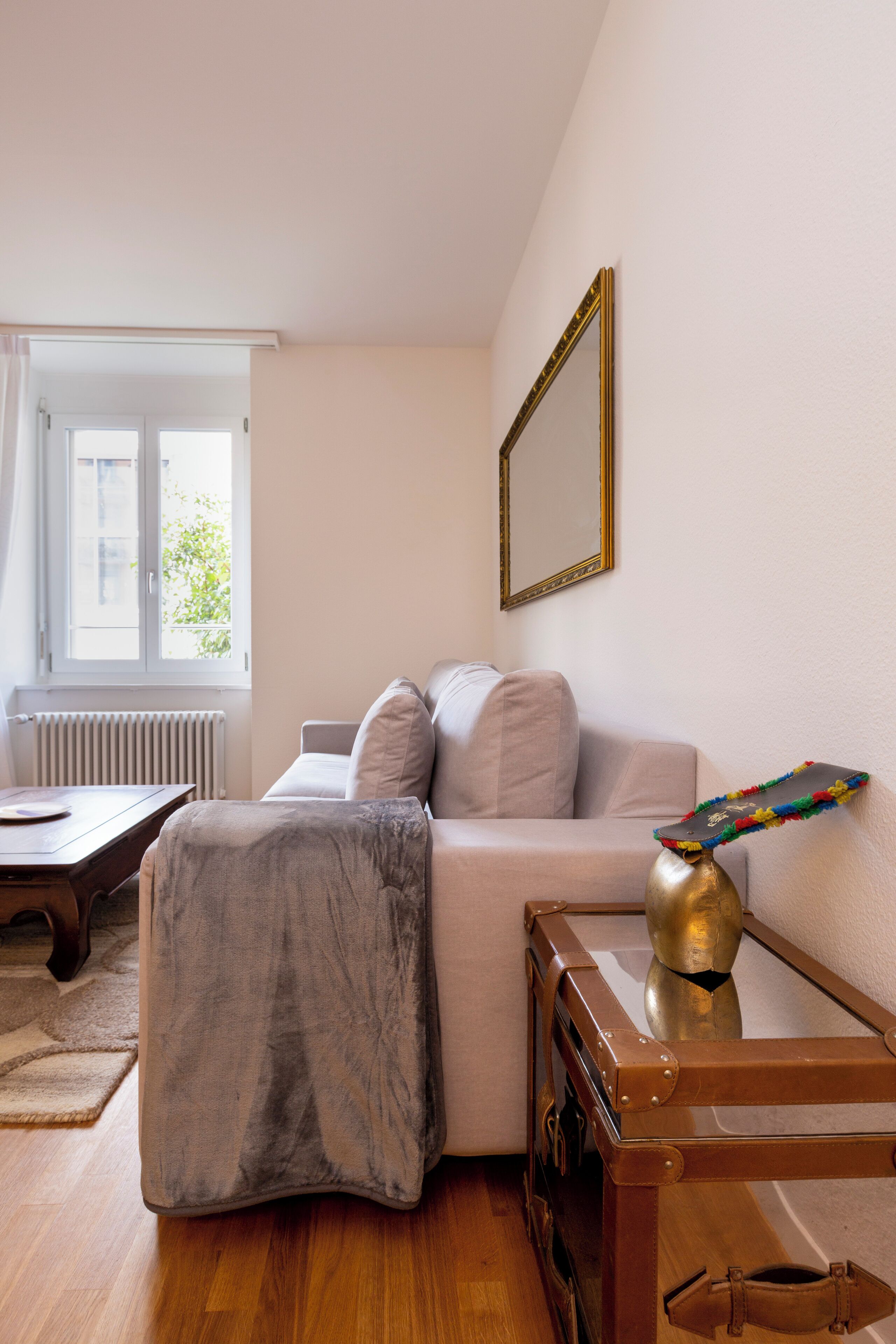 A cozy living room with a sofa, a coffee table, and a decorative vase.