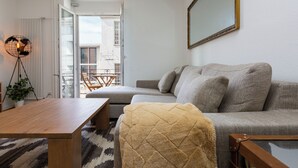 A modern living room with a grey sofa, a wooden coffee table, and a floor lamp. - KAYA Zurich Elisabethenstrasse (Zürich)