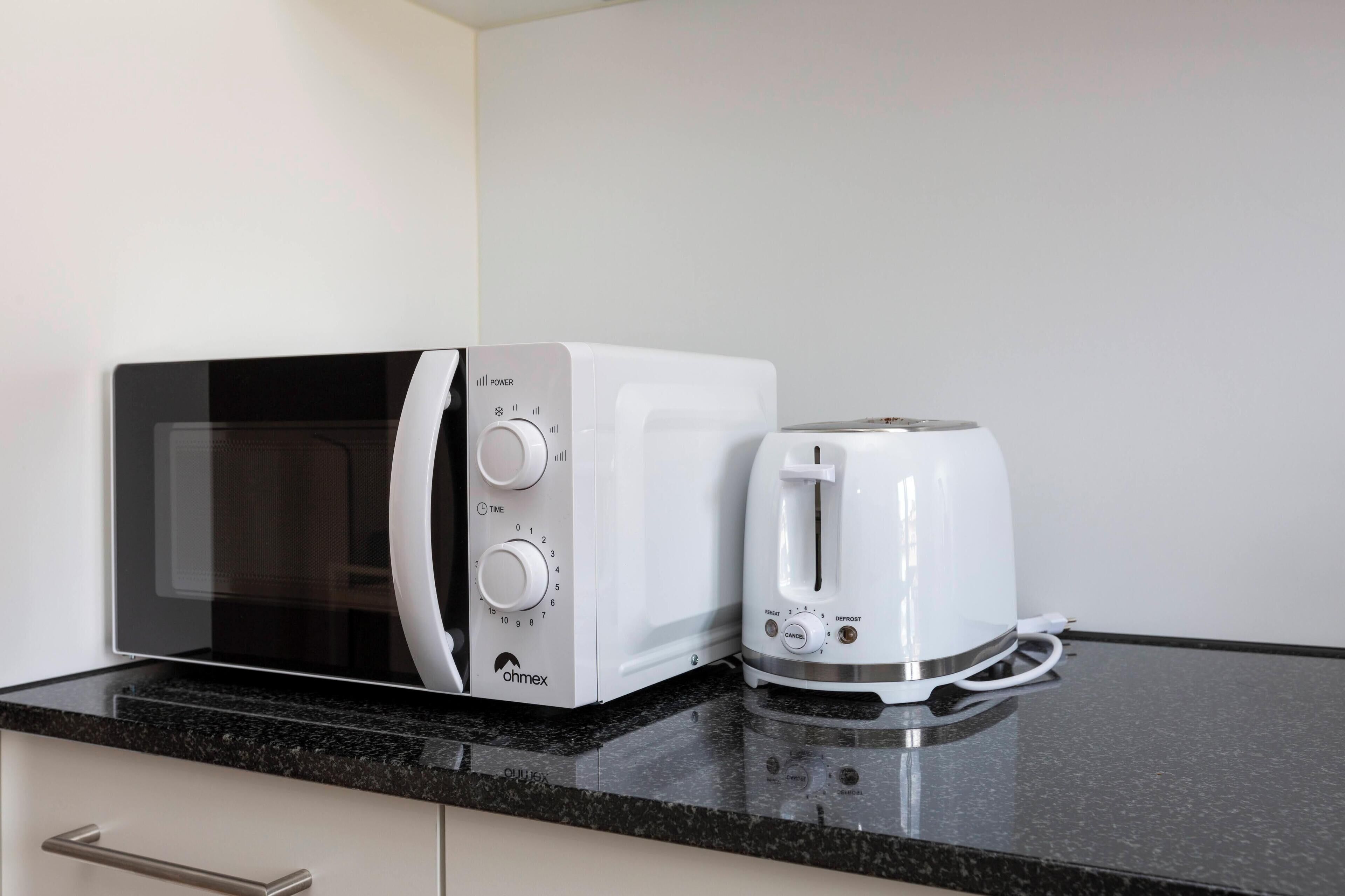Eine Mikrowelle und ein Toaster auf einer Küchenarbeitsplatte.