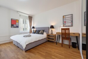 Relax in a stylish room with a comfortable bed, desk, and large window.