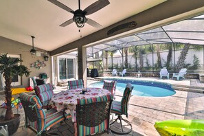 Relax by the pool in this inviting outdoor space, featuring a dining table and comfortable seating.