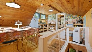 A cozy, wooden-paneled kitchen with a dining area, a refrigerator, and a microwave.