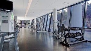A modern gym with various exercise equipment, large windows, and a clean, spacious layout. - 1 Bedroom + Study Ocean View Apartment — Q Stay (COC 1313 - 2N - NB) (Surfers Paradise)