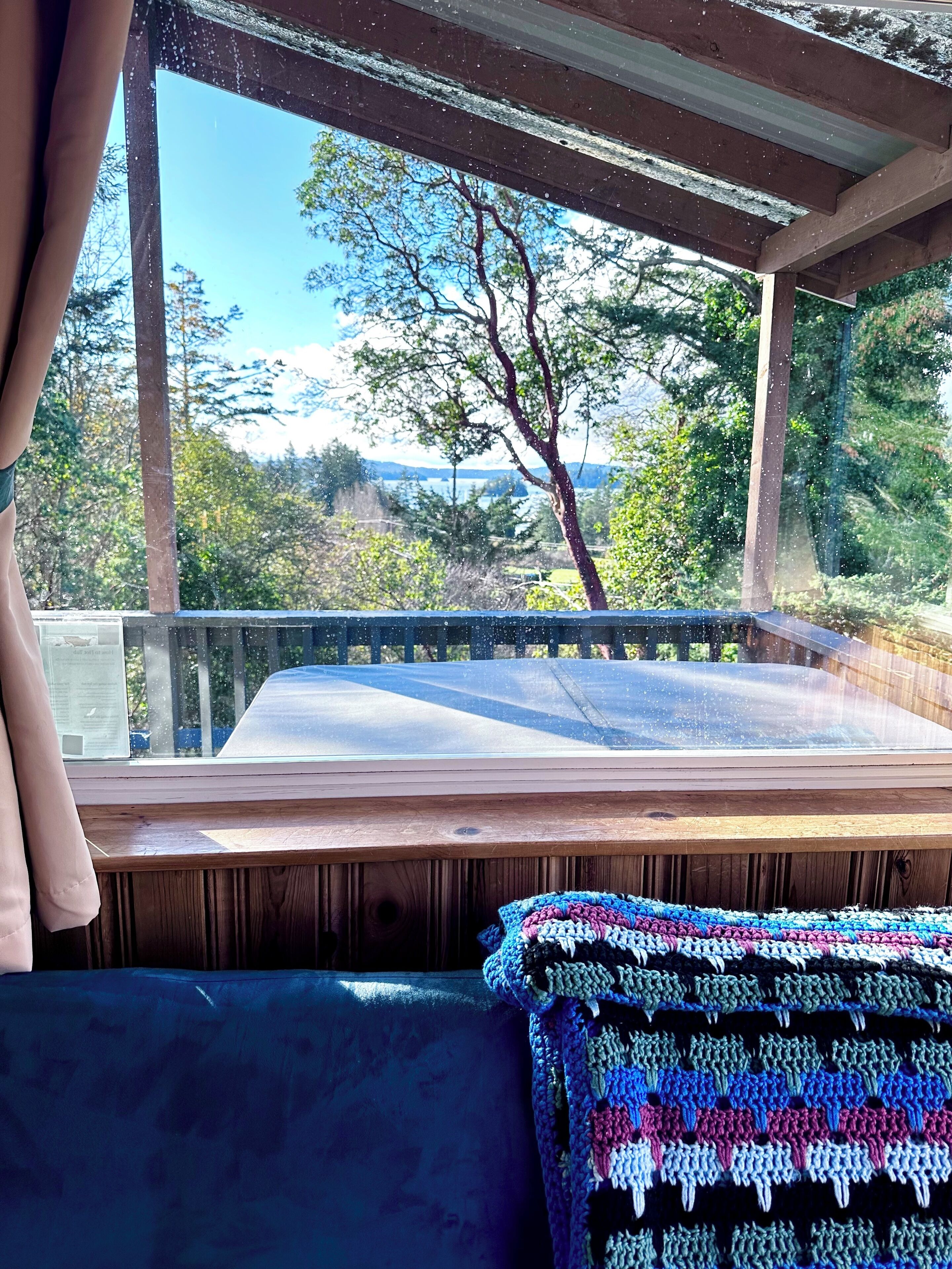 Eine Holzterrasse mit Blick auf Bäume und eine entfernte Landschaft.